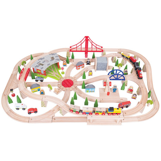 Wooden toy train set with tracks, cars, and small buildings on a white background