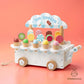 Wooden ice cream cart toy with colorful ice cream cones on a pink background, brand 'KidsNaturica' visible.