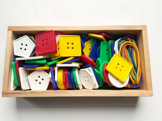 LACING BUTTONS AND LACES IN A WOODEN TRAY
